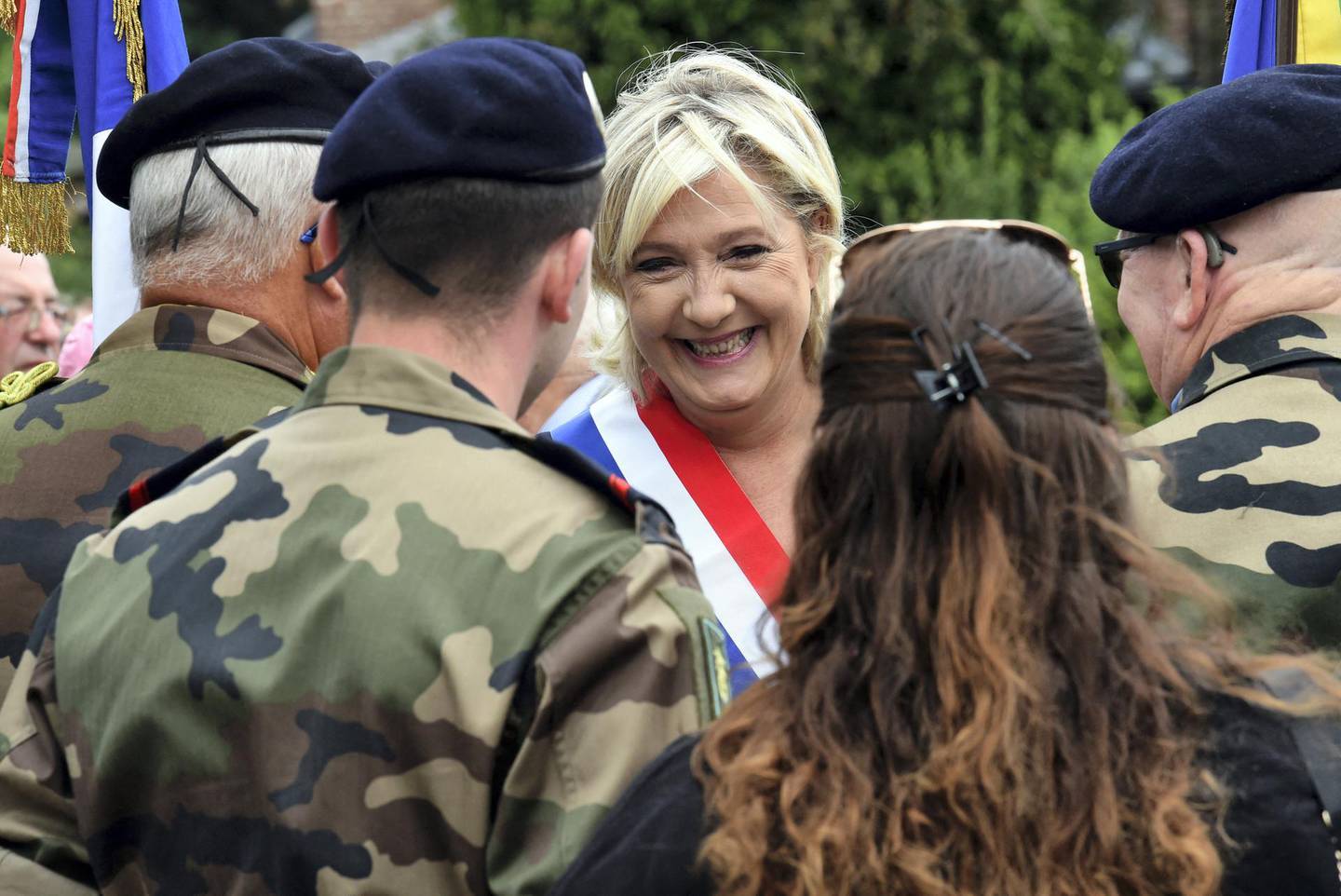 Far-right Front National (FN) party member of parliament Marine Le Pen speaks with military personnel as she attend the annual Bastille Day celebrations in Henin-Beaumont, northwestern France on July 14, 2017. (Photo by FRANCOIS LO PRESTI / AFP)