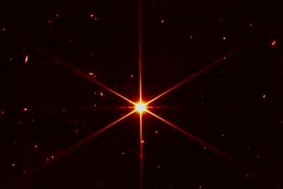 This image made available by Nasa on March 16, 2022 shows star 2MASS J17554042+6551277 used to align the mirrors of the James Webb Space Telescope, with galaxies and stars surrounding it.  The hexagonal shape of Webb’s mirrors and its filters made the shimmering star look more red and spiky.  The first science images aren't expected until July 12. Photo: Nasa 