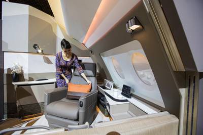 A flight attendant arranges a pillow on a leather seat in a mock-up Suite, designed by Pierrejean Design Studio, during the unveiling of the new cabins for the Singapore Airlines. Bloomberg