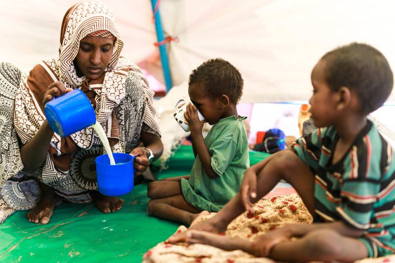 Waaf Dhuung, Ethiopia - April 03: A mother prepares milk from milk powder for her children. Unicef feeding in a village in the Somali region of Ethiopia, where Pastorale (Ethiopian nomads) settled because of the persistent drought on April 03, 2017 in Waaf Dhuung, Ethiopia. (Photo by Michael Gottschalk/Photothek via Getty Images)
