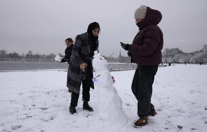 French students build a snowman in Kensington Gardens in London. The UK has cut energy imports from across the Channel. AP