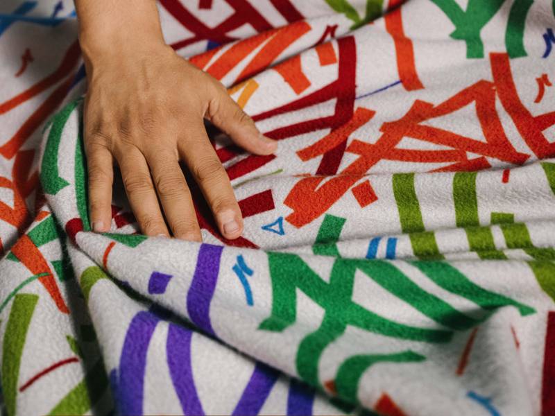 The cashmere fabric is treated with the “frisson” finish: a gentle brushing process that lends lustre to the surface and accentuates the colours of the artwork.