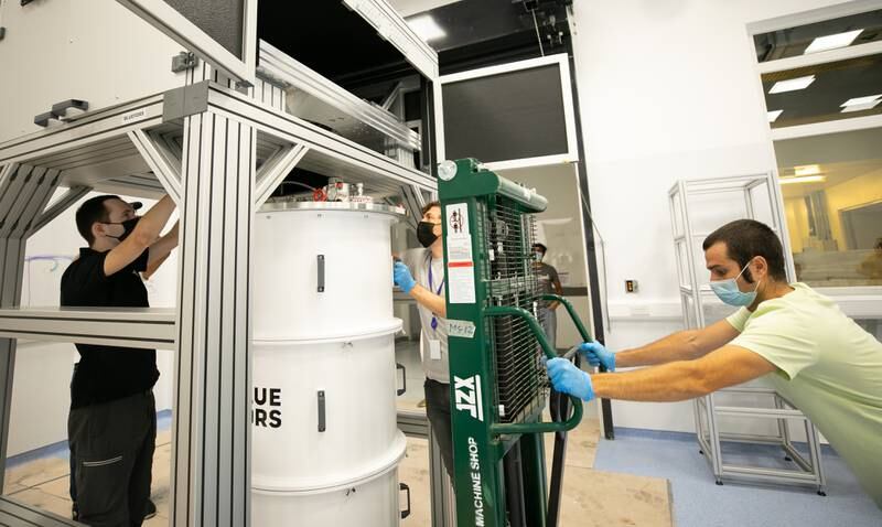 The cryostat is positioned and hung from a frame, enabling it to be opened and closed. The frame contains the helium dilution refrigerator that helps maintain an extremely low temperature using helium isotopes.
