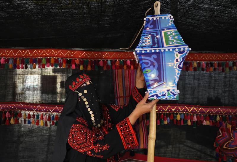 A Palestinian woman hangs a fanous lantern in Gaza City. AFP