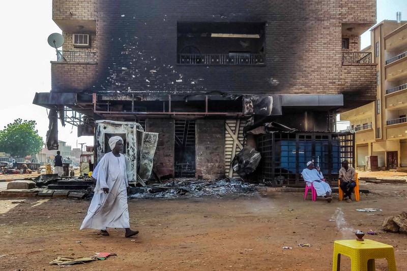 A man walks past a burnt-out bank in southern Khartoum last week. The conflict in Sudan is an acute security crisis for the Arab world and Africa. AFP