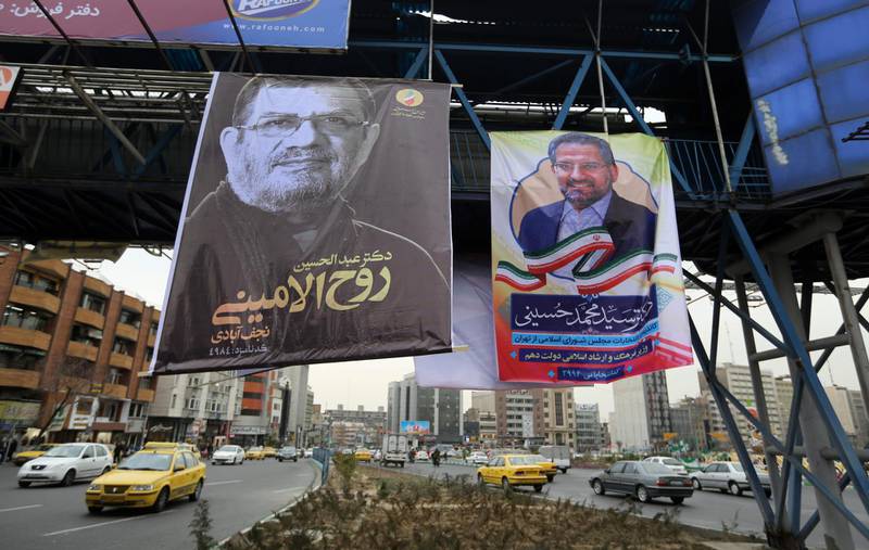 Iranians drive their cars past electoral posters and fliers during the last day of election campaign in the capital Tehran. AFP
