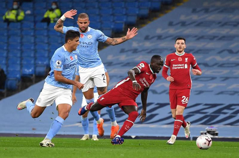 Manchester City defender Kyle Walker, second left, brings down Liverpool's Sadio Mane to give the Merseysiders a penalty at the Etihad Stadium. PA