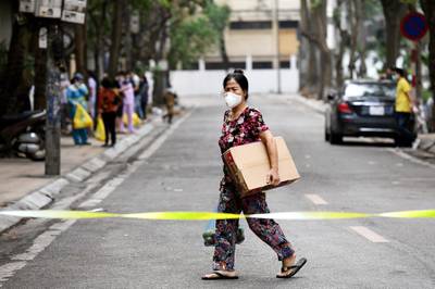 A woman walks inside an isolated area on Truc Bach street in Hanoi.  AFP