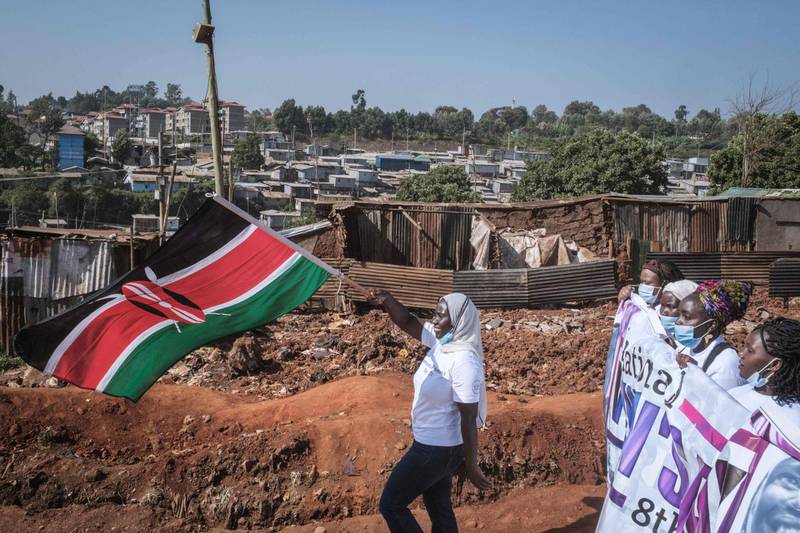 A woman waves the national flag of Kenya as female human rights defenders from 26 community-based organisations march to commemorate International Women's Day in Kibera, Nairobi. AFP
