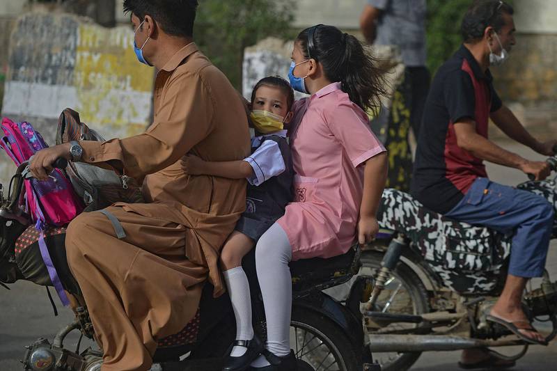 Children are taken to school in Karachi after the Pakistan government said in-person classes could resume. AFP
