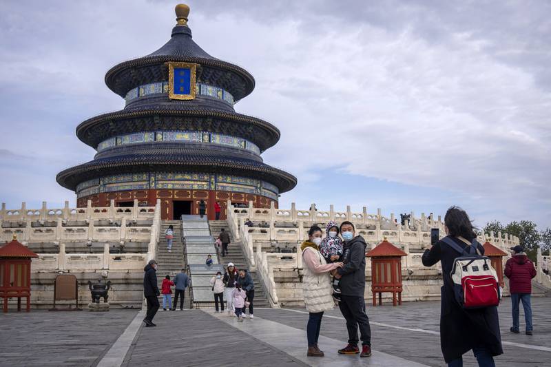 A family taking pictures at the Temple of Heaven in Beijing. The world's population hit an estimated eight billion people on Tuesday, according to a United Nations projection. AP