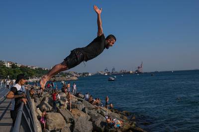 A young boy jumps into the Bosphorus to beat the heat amid the ongoing coronavirus pandemic in Istanbul, Turkey. EPA