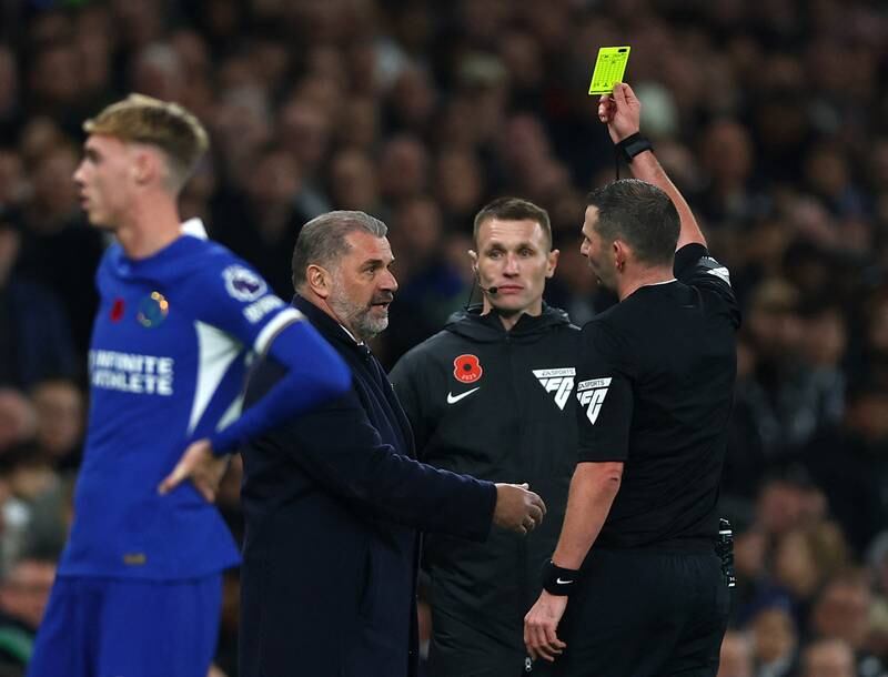 Tottenham Hotspur manager Ange Postecoglou is shown a yellow card by referee Michael Oliver. Reuters