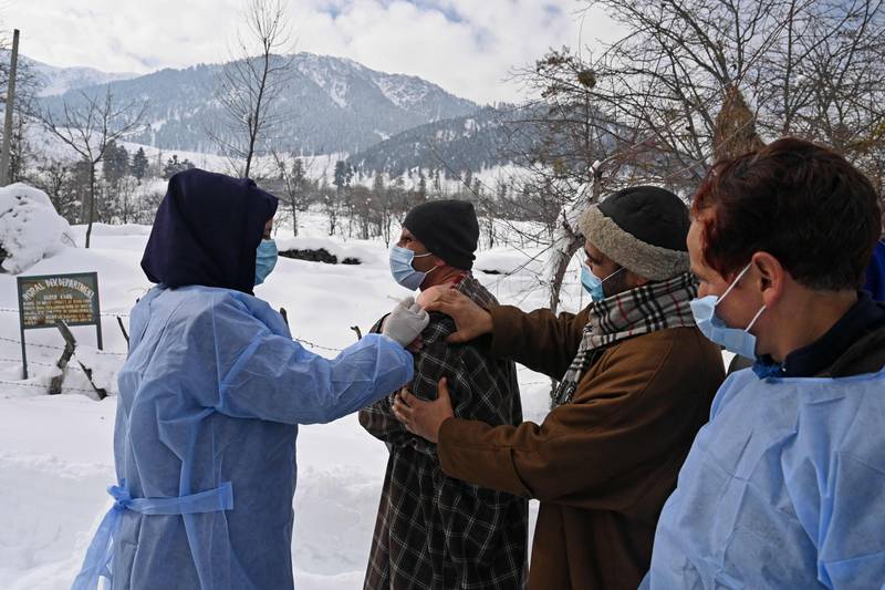 A health worker inoculates a man with a dose of the Covishield vaccine during a vaccination drive in Khag village in Budgam district of Indian-administered Kashmir. AFP