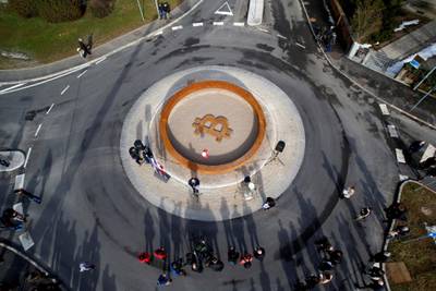 People attend the opening ceremony of world's first public Bitcoin monument, placed at a roundabout connecting two roads at the city centre in Kranj, Slovenia, March 13, 2018. REUTERS/Borut Zivulovic NO ARCHIVES. NO RESALES.     TPX IMAGES OF THE DAY