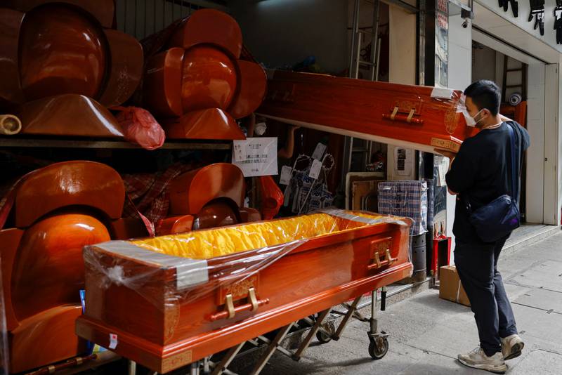 Workers move coffins as mortuaries run short of coffins in Shenzhen. Photo: Reuters