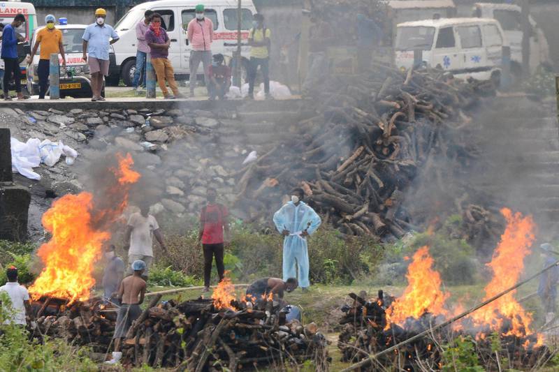 People watch the funeral pyres of those who died with Covid-19 at Sahudangi Crematorium. AFP