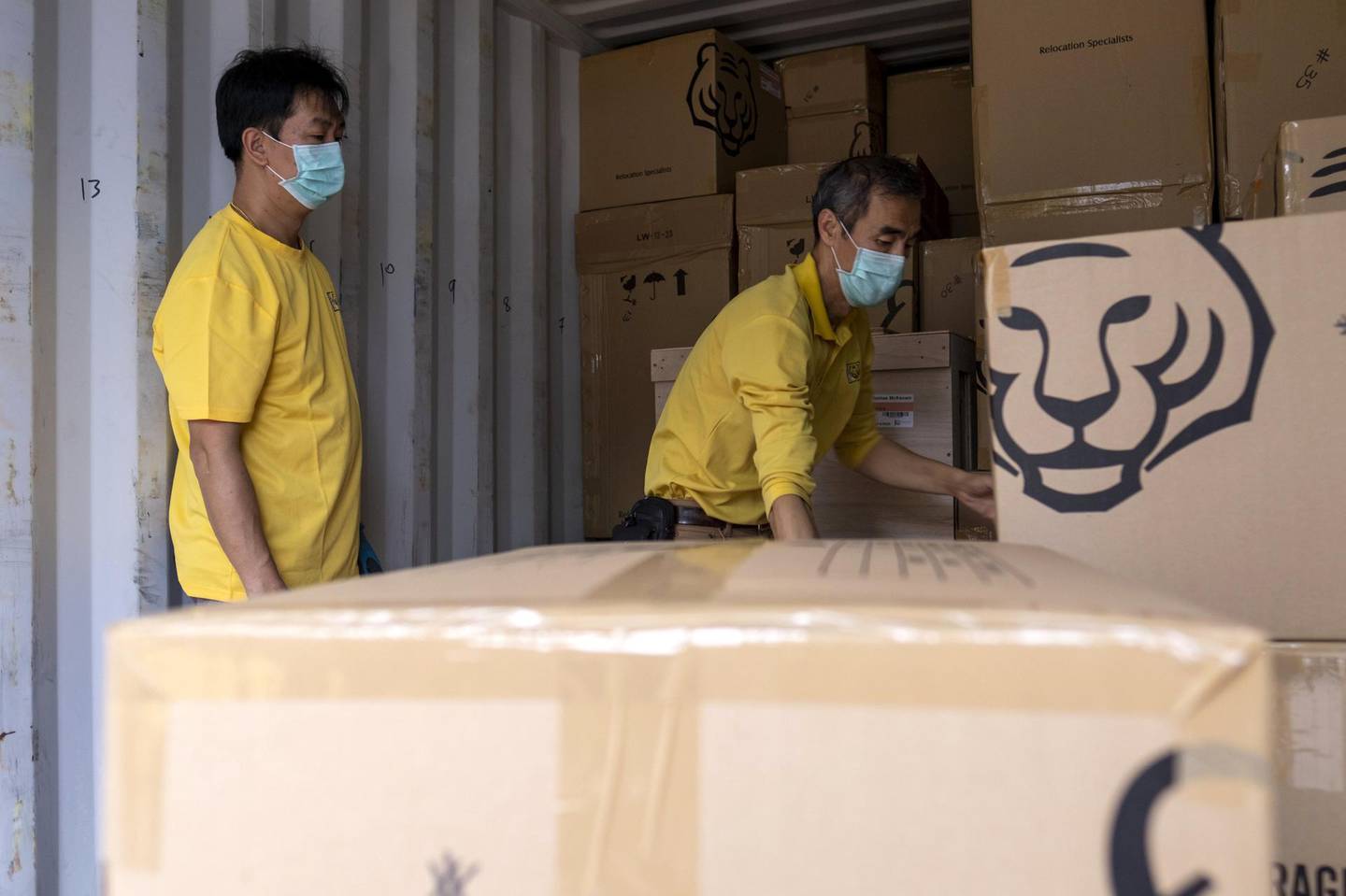 Asia Tigers Group employees arrange boxes inside a shipping container, during a customer's relocation overseas, in Hong Kong, China, on Friday, Feb. 14, 2020. The debate about leaving Hong Kong -- which began for many expats during the unrest last summer and fall -- has taken on a greater urgency with the spread of the coronavirus, which has claimed more than 1,800 people globally, and caused many companies in the financial hub to require employees to work from home.Â Photographer: Justin Chin/Bloomberg via Getty Images