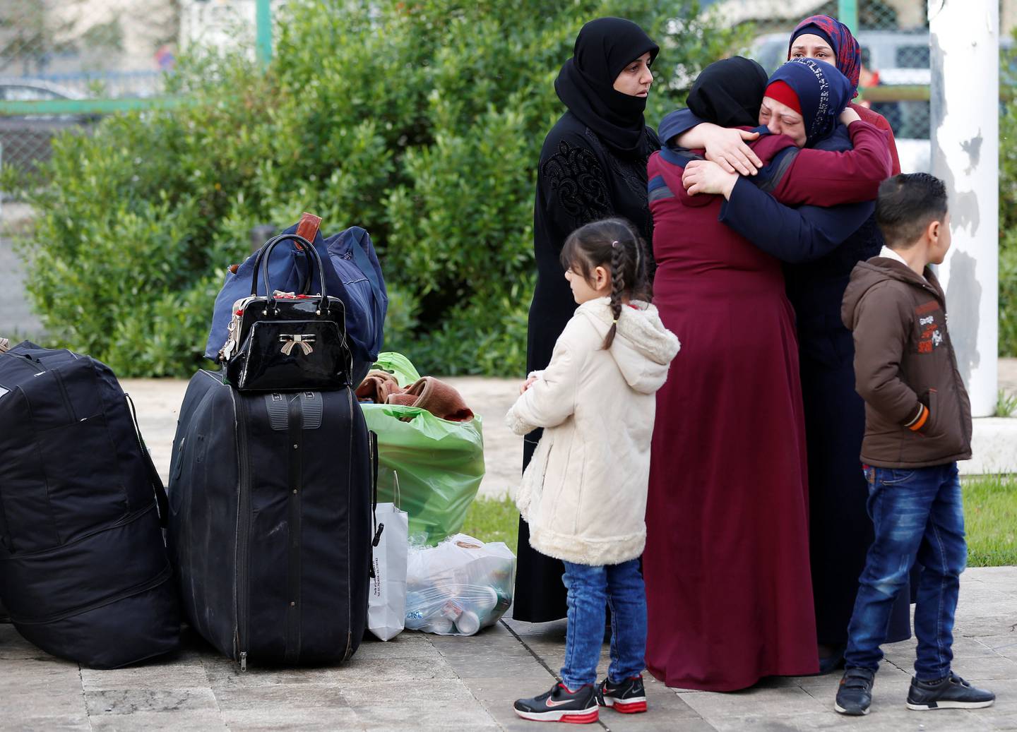 Une jeune fille réfugiée syrienne se tient près des bagages des réfugiés syriens rentrant en Syrie, à Beyrouth, au Liban, le 6 décembre 2018. Photo prise le 6 décembre 2018. REUTERS/Jamal Saidi