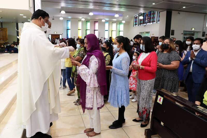 Father Andre gives communion at St Mary's Catholic Church Dubai. Pawan Singh / The National