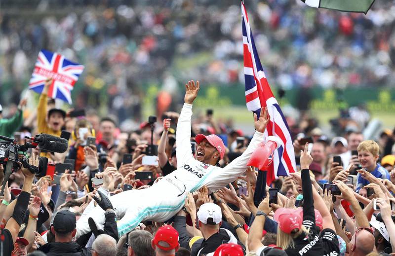 NORTHAMPTON, ENGLAND - JULY 14: Race winner Lewis Hamilton of Great Britain and Mercedes GP celebrates with fans after the F1 Grand Prix of Great Britain at Silverstone on July 14, 2019 in Northampton, England. (Photo by Mark Thompson/Getty Images)