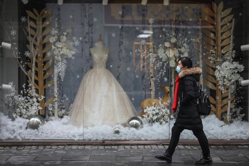 WUHAN, CHINA - JANUARY 22: (CHINA OUT) A woman wears a mask while passing in front of wedding shop on January 22, 2020 in Wuhan, Hubei province, China. A new infectious coronavirus known as "2019-nCoV" was discovered in Wuhan as the number of cases rose to over 400 in mainland China. Health officials stepped up efforts to contain the spread of the pneumonia-like disease which medicals experts confirmed can be passed from human to human. The death toll has reached 17 people as the Wuhan government issued regulations today that residents must wear masks in public places. Cases have been reported in other countries including the United States, Thailand, Japan, Taiwan, and South Korea.  (Photo by Getty Images)