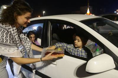 A girl hands out sweets in Damascus to express solidarity with Palestine.  AFP