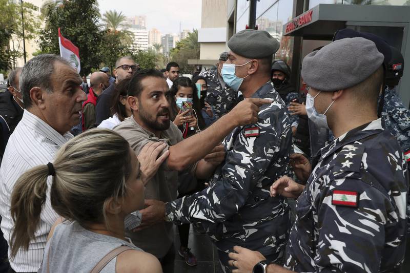 Bank customers scuffle with riot police as they try to storm a bank in Beirut, Lebanon. AP