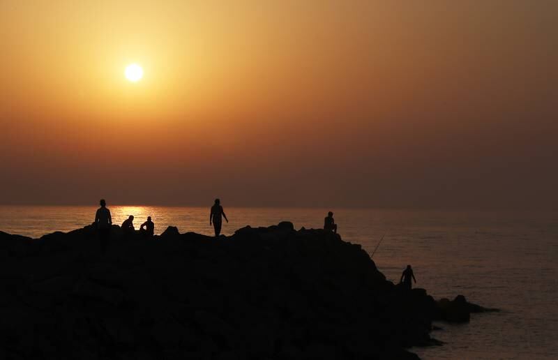 People spending time enjoying a spectacular sunset near the beach in Ras Al Khaimah. Pawan Singh / The National