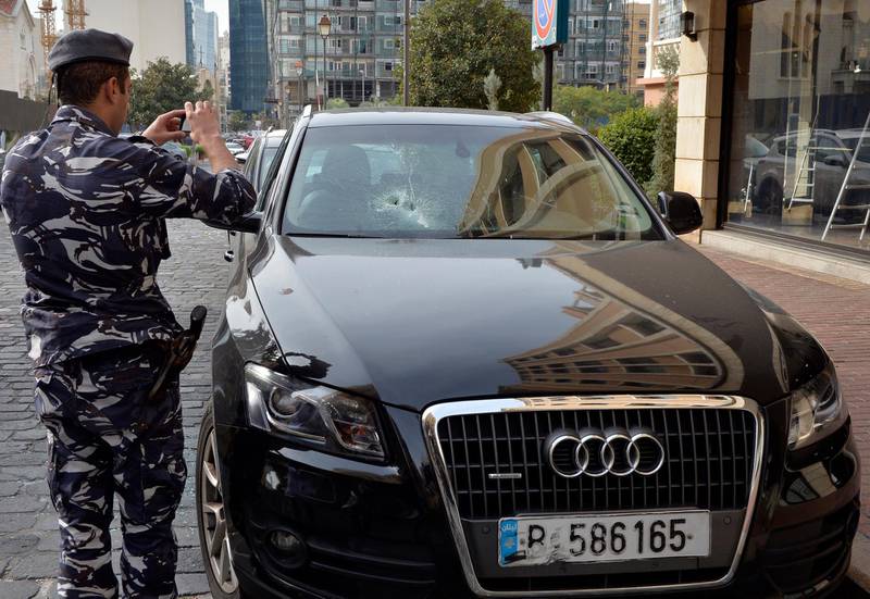 A policeman takes a picture of a damaged car after a night of clashes between supporters of Hezbollah and Amal Movement with anti-government protesters in Beirut.  EPA