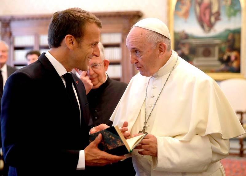 French President Emmanuel Macron (L) exchanges gifts with Pope Francis at the end of a private audience at the Vatican on June 26, 2018.    / AFP / POOL / Alessandra Tarantino
