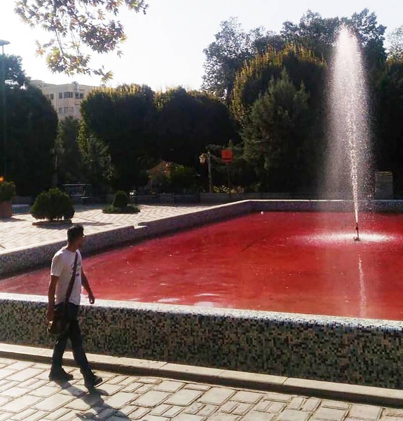 This UGC image made available on twitter on October 7, 2022 shows a man walking past the fountain of Park Daneshjoo or Student Park in the Iranian capital Tehran, reportedly coloured red in protest against a bloody crackdown on three weeks of protests sparked by the death in custody of Mahsa Amini.  - Activists who took to Twitter described the red fountains as "works of art" titled "Tehran covered in blood" and that they were created by an anonymous artist in more than one fountain located in downtown Tehran -- one in Student Park, another in Fatemi Square as well as in the Artists' Park.  (Photo by UGC  /  AFP)  /  XGTY / RESTRICTED TO EDITORIAL USE - MANDATORY CREDIT AFP -  SOURCE: ANONYMOUS - NO MARKETING - NO ADVERTISING CAMPAIGNS - NO INTERNET - DISTRIBUTED AS A SERVICE TO CLIENTS - NO RESALE - NO ARCHIVE - AFP IS NOT RESPONSIBLE FOR ANY DIGITAL ALTERATIONS TO THE PICTURE'S EDITORIAL CONTENT  /  