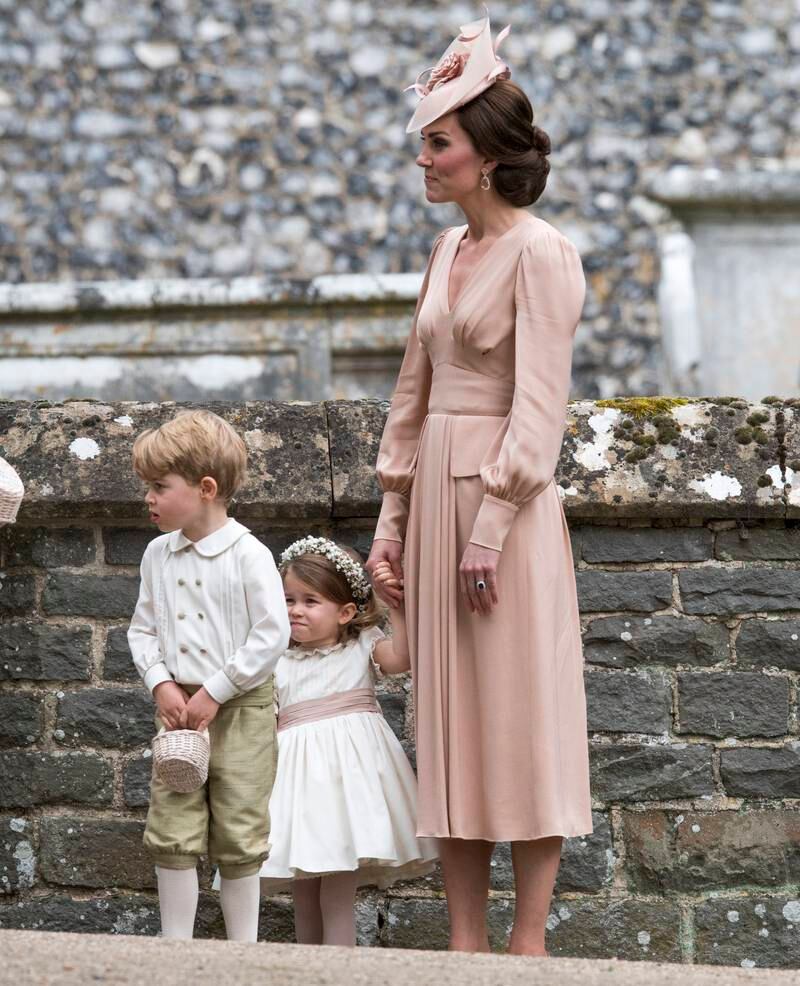 Kate speaks to Princess Charlotte and Prince George after the wedding of her sister Pippa Middleton and James Matthews at St Mark's Church, Englefield, in May 2017.