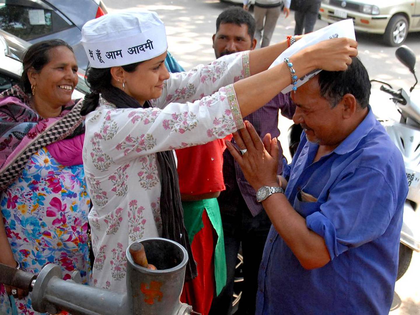 Gul Panag presents a cap to a street vendor as she campaigns before the national elections in Chandigarh in 2014. AFP