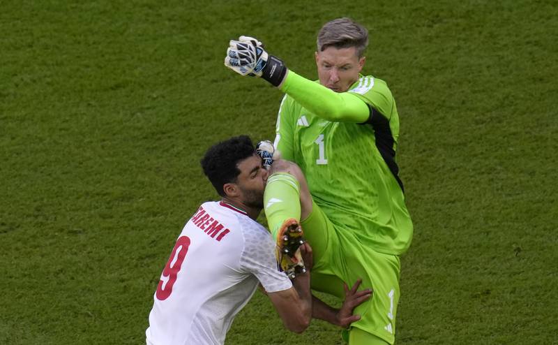 Wales's goalkeeper Wayne Hennessey, right, collides with Iran's Mehdi Taremi. He was sent off shortly after. AP Photo
