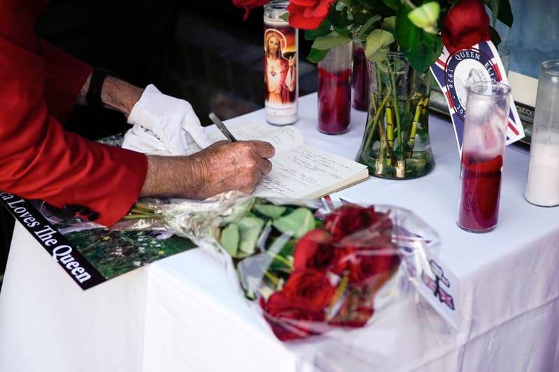 A patron writes in a notebook with messages about Queen Elizabeth as her state funeral is replayed at the British restaurant and pub Ye Olde King's Head in Santa Monica, California. EPA