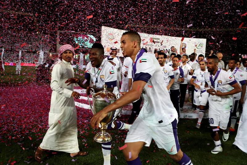 Asamoah Gyan, centre, and Ismail Ahmed, right, of Al Ain run with the trophy after deafting Al Ahli in the President's Cup final on Sunday. Christopher Pike / The National / May 18, 2014