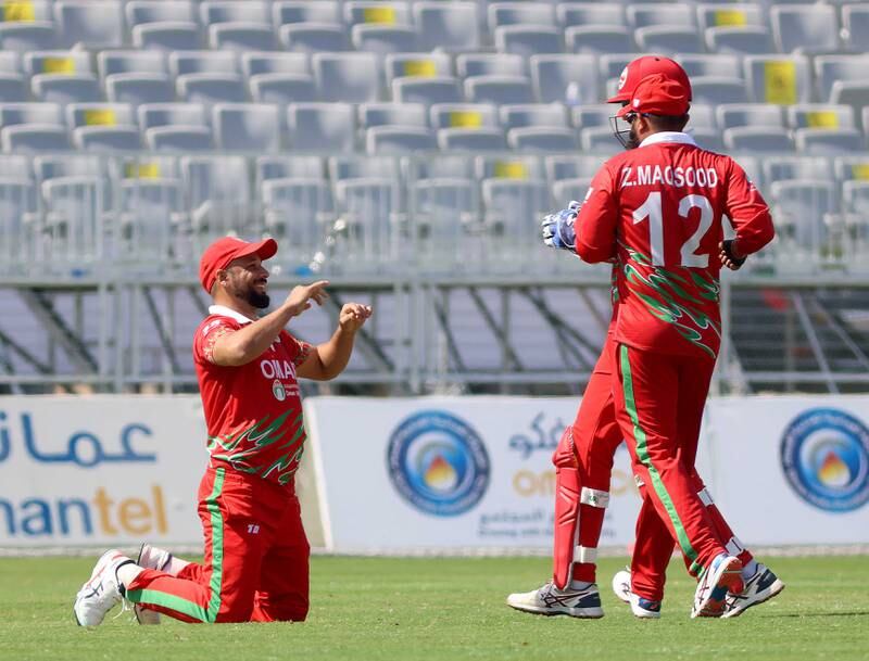 Oman celebrate a wicket.