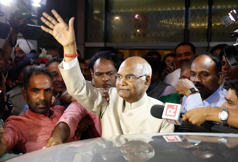 FILE- In this June 19, 2017, file photo, Ram Nath Kovind, center, waves to media upon arrival at the airport in New Delhi, India. Kovind, 71, a Hindu nationalist leader has been elected India's new president, a largely ceremonial position. (AP Photo/Tsering Topgyal, file)