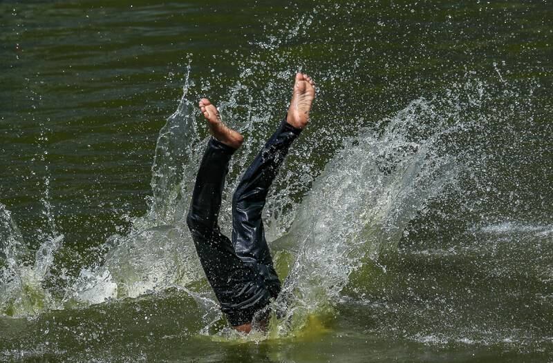 A boy jumps into a pond in Mumbai. Large parts of India are experiencing the hottest April on record. EPA