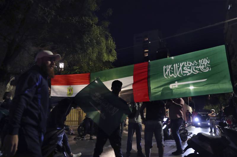 Lebanese men hold Saudi Arabia, UAE and Egypt flags during a protest against the comments made by Lebanese Information Minister George Kordahi. AP