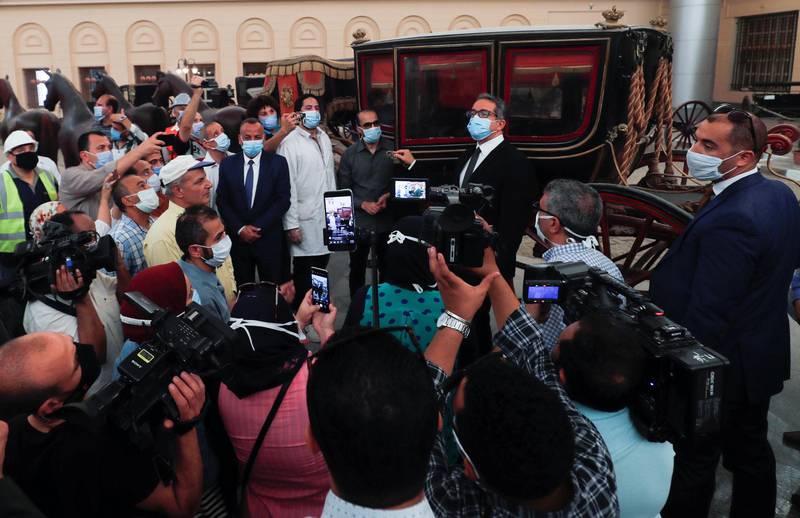 Egypt's Antiquities and Tourism Minister Khaled al-Anany wears a protective face mask as he talks to media next to one of the 19th-century royal family carriages at The Royal Carriages Museum after it's reopening in Cairo, Egypt. Reuters