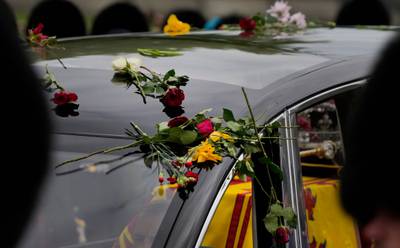 The hearse transporting the coffin is covered in flowers thrown by the public. AFP