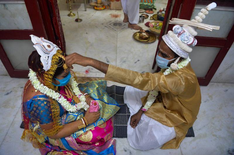 Groom Sanjib Mandal, right, and bride Soma Roy wear masks as they perform rituals on their marriage ceremony at a Hindu temple amid the nationwide lockdown against the coronavirus, in Siliguri. AFP