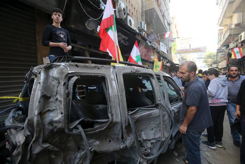 Residents inspect a burnt vehicle a day after two suicide bombers set off explosions in the southern suburbs of Beirut on November 12, 2015. Hasan Shaaban / Reuters