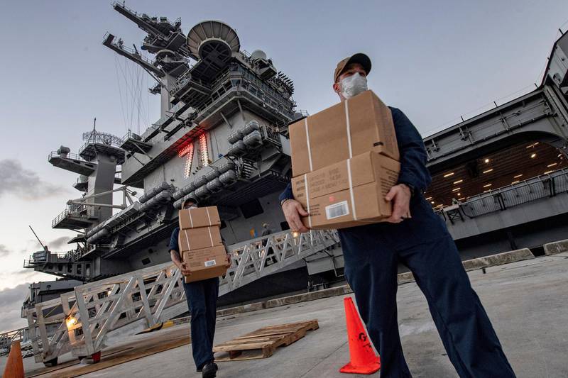 In this April 7, 2020, photo released by the U.S. Navy, sailors assigned to the aircraft carrier USS Theodore Roosevelt move ready to eat meals for sailors who have tested negative for COVID-19 and are being taken to local hotels in an effort to implement social distancing at Naval Base Guam. People in Guam are used to a constant U.S. military presence on the strategic Pacific island, but some are nervous as hundreds of sailors from the coronavirus-stricken Navy aircraft carrier flood into hotels for quarantine. Officials insist they have enforced strict safety measures. (Mass Communication Specialist Julio Rivera/U.S. Navy via AP)