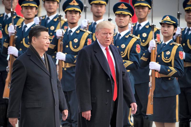 China's President Xi Jinping (L) and US President Donald Trump review Chinese honour guards during a welcome ceremony at the Great Hall of the People in Beijing on November 9, 2017. / AFP PHOTO / NICOLAS ASFOURI