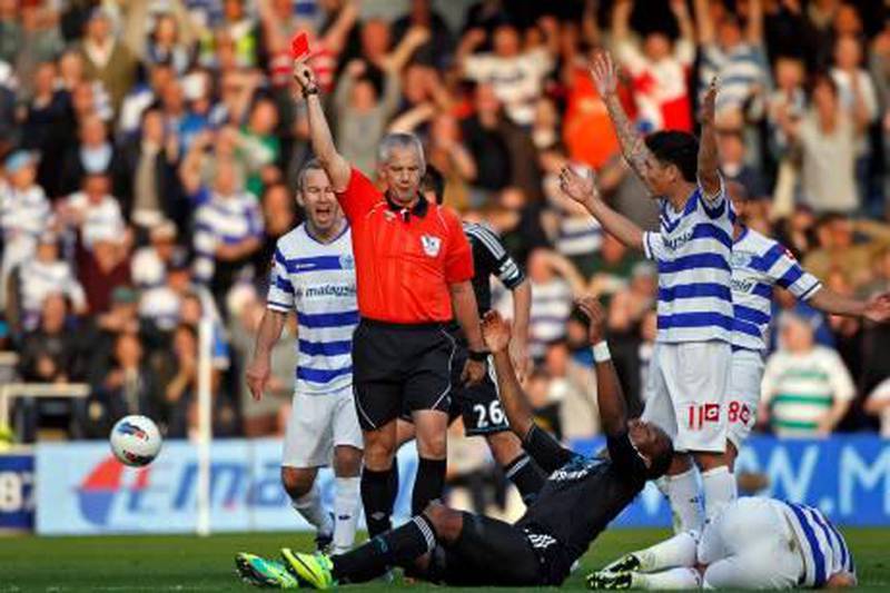 epa02978228 Chelsea's Didier Drogba (C, in dark blue) reacts as referee Chris Foyle (C) shows him a red card after he fouled Queens Park Rangers' Adel Taarabt (R, on the turf) during the English Premier League soccer match at Loftus Road Stadium in London, Britain, 23 October 2011.  EPA/KERIM OKTEN DataCo terms and conditions apply http//www.epa.eu/downloads/DataCo-TCs.pdf *** Local Caption ***  02978228.jpg