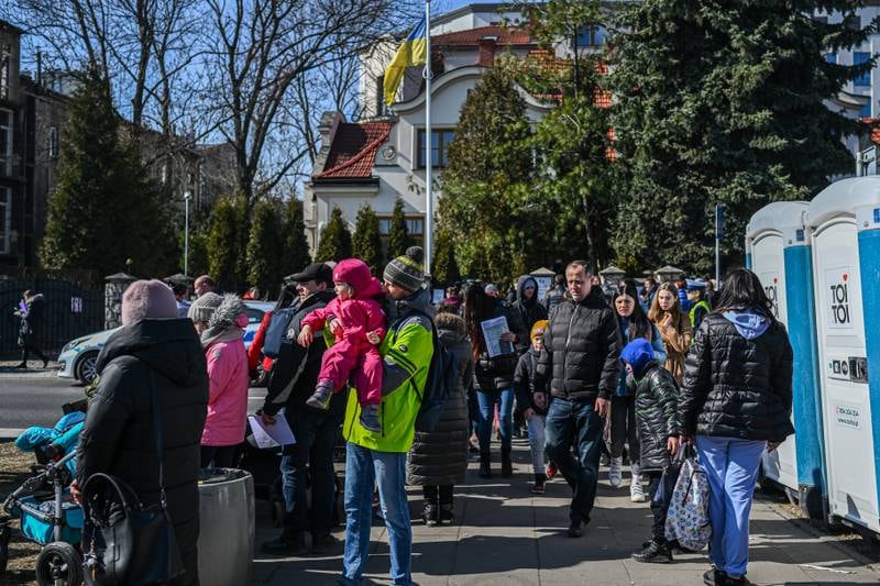 People who fled the war in Ukraine pictured queueing for assistance at the Ukrainian consulate in Krakow, Poland. Getty Images