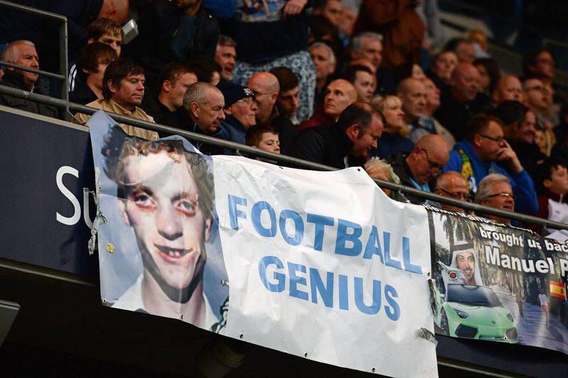 A poster featuring Manchester United manager David Moyes is pictured beside Manchester City fans during their match against West Bromwich Albion on Monday. Andrew Yates / AFP / April 21, 2014 